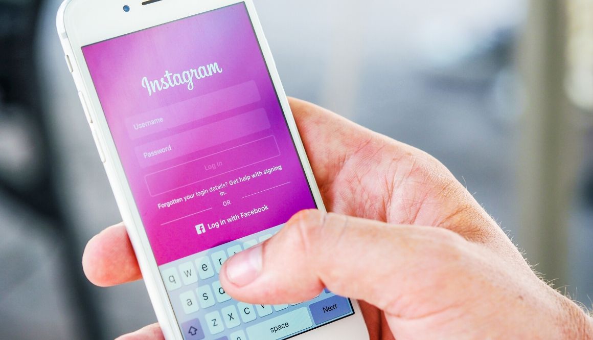  A hand holding a phone with the Instagram login page on the screen.